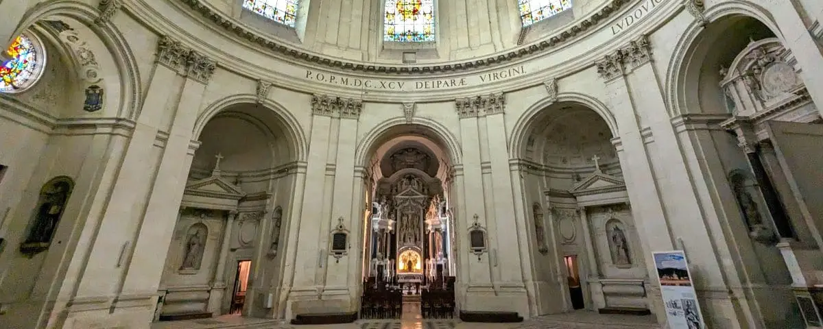 Interior view of Ardilliers Chapel in Saumur, showcasing its grand architecture with ornate arches and a central altar illuminated under stained glass windows.