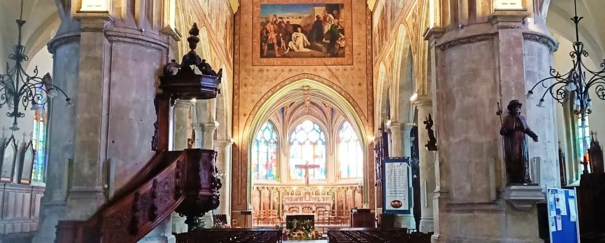 The interior of the Church of Saint-Étienne in Fécamp, showcasing its ornate architecture, stained glass windows, and detailed altar.