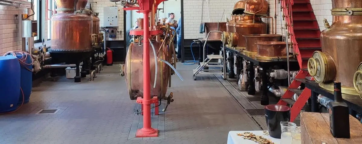 Interior of the Combier Distillery in Saumur, showing large copper stills and other distillation equipment used in the production of spirits.