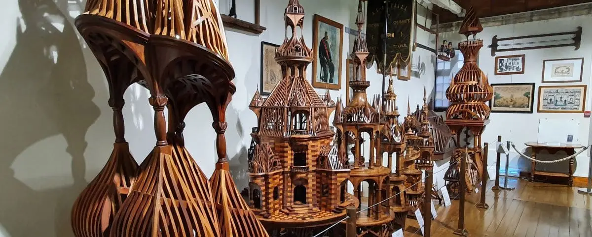 An exhibit of intricate wooden models and structures displayed in the Compagnonnage Museum in Tours, France, highlighting craftsmanship and architectural details.
