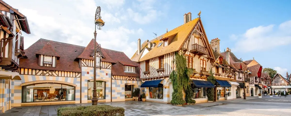 Picturesque street view of Deauville town, featuring traditional half-timbered buildings and quaint shops.