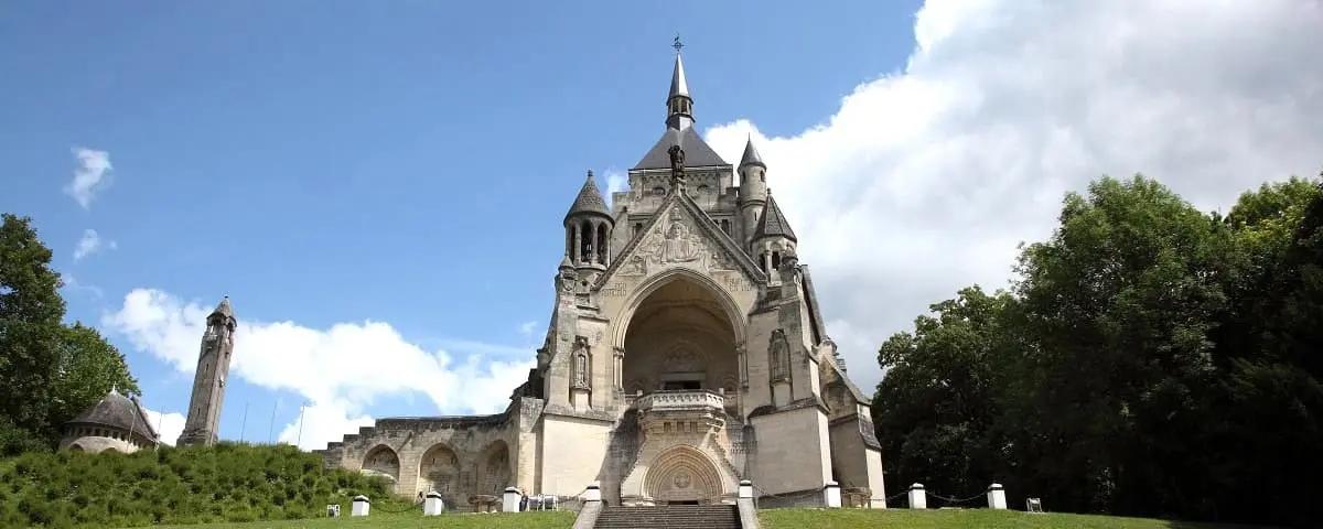 The Dormans Memorial, a historic monument with intricate stonework, set atop a hill with steps leading to its grand entrance.
