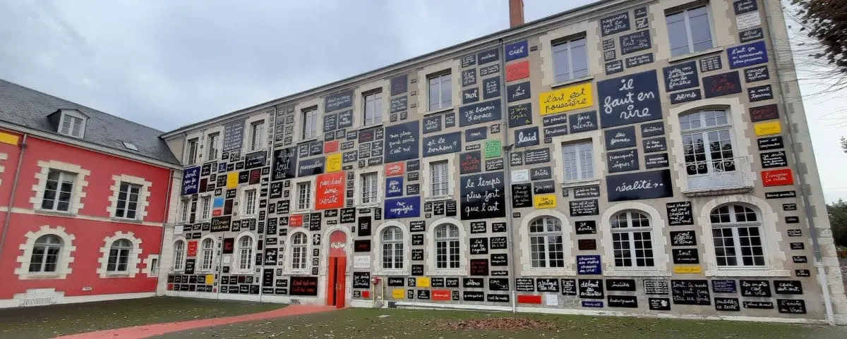 A unique museum building covered with colorful and artistic signs and phrases, creating a vibrant and eclectic exterior.