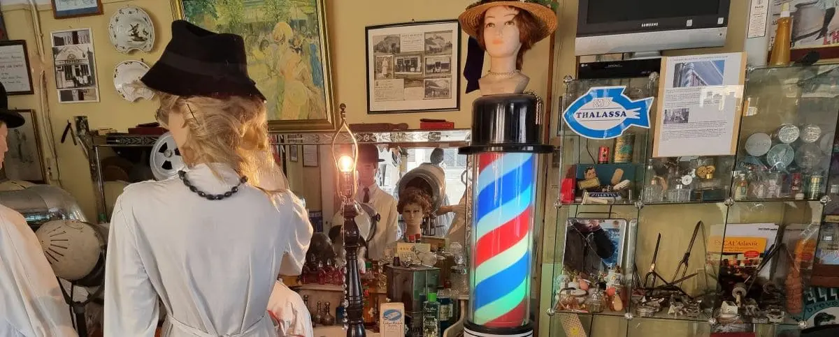 Inside the Hair Salon Museum in Le Havre, displaying vintage hairdressing tools, mannequins with period hairstyles, and a classic barber pole.