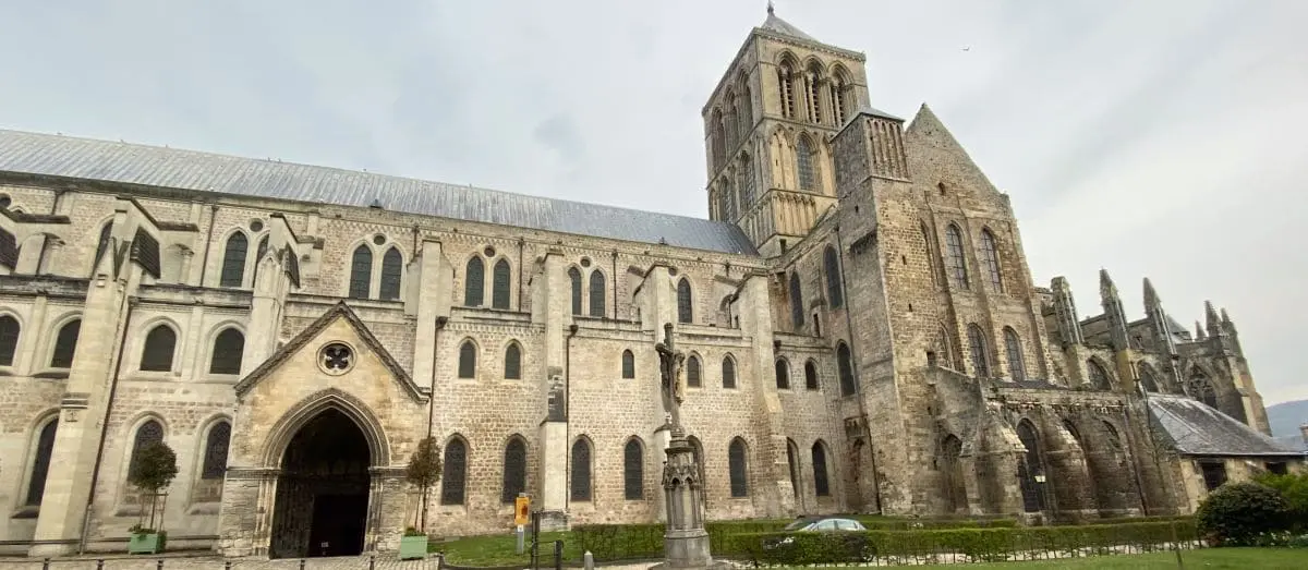 The exterior of the Holy Trinity Abbey in Fécamp, a historic stone building with gothic architectural features and a prominent bell tower.