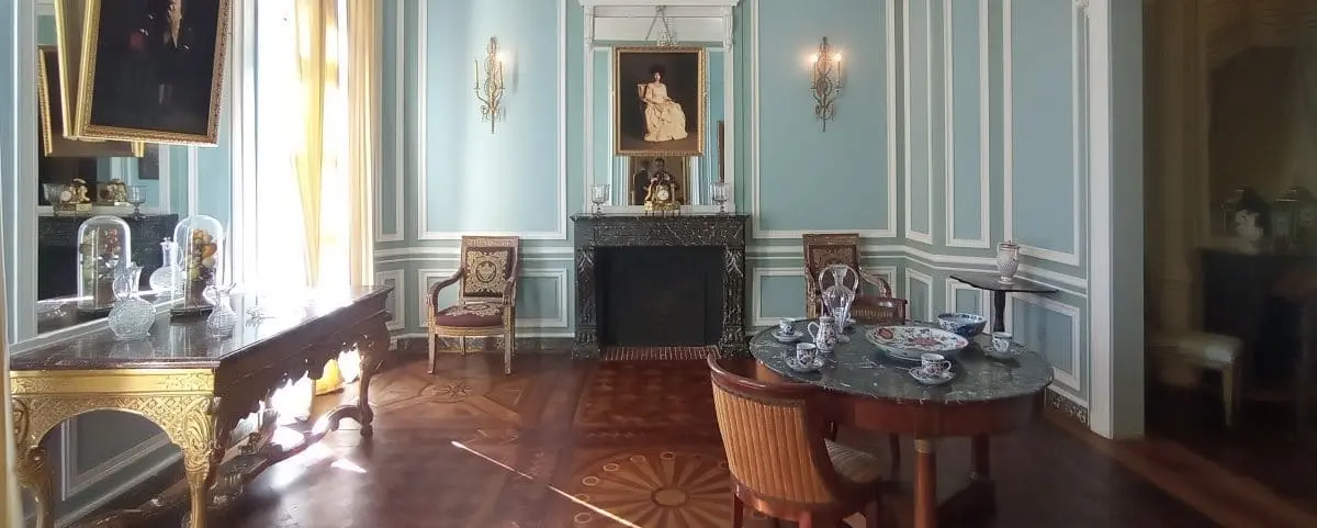An elegant room in Maison de l'Armateur in Le Havre, featuring ornate furniture, a fireplace, and a portrait above the mantel.