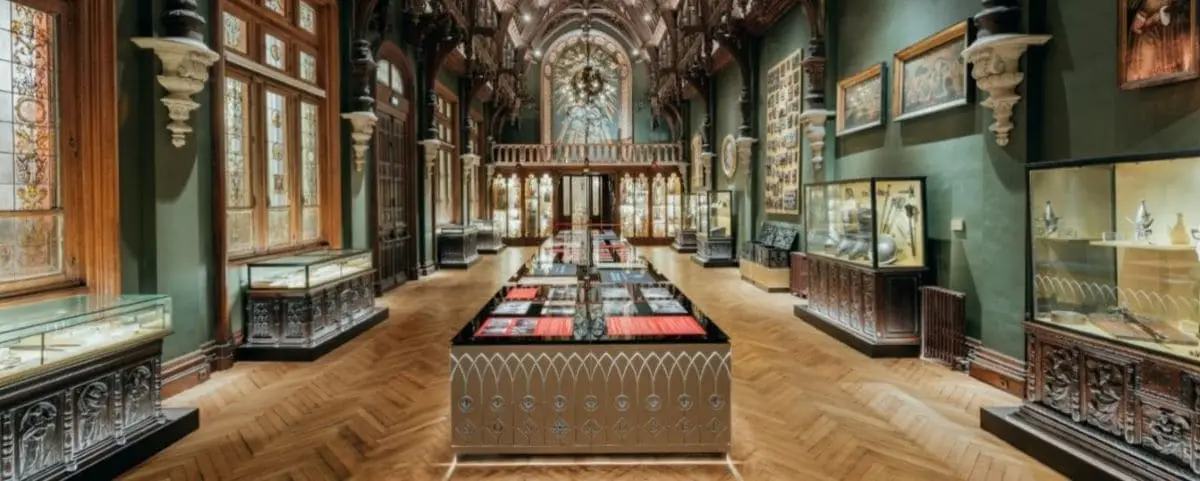 The interior of the Palais Bénédictine in Fécamp, featuring ornate architecture, stained glass windows, and elaborate displays of historical artifacts.