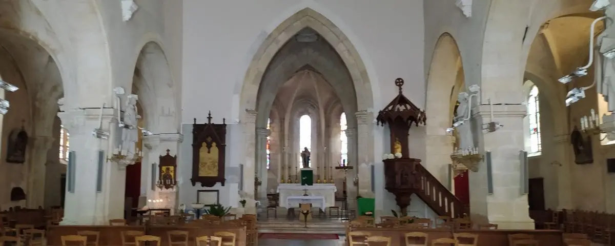 The interior of Saint-Martin Church in Valençay, featuring a spacious nave with arched ceilings, wooden pews, and a central altar.