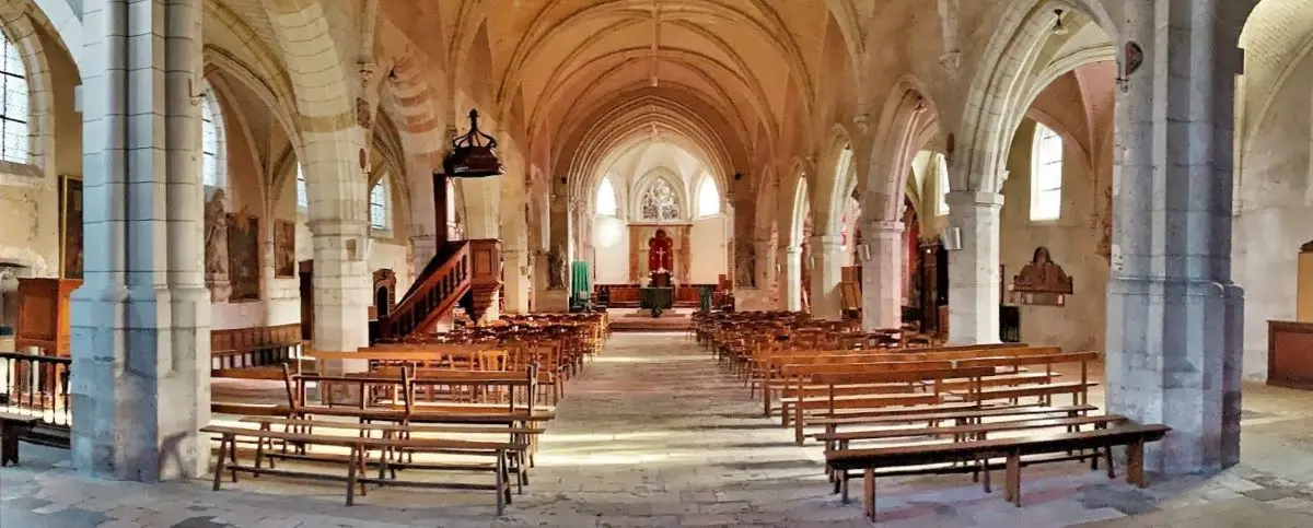 A serene church interior with stone arches, wooden pews, and a modest altar.