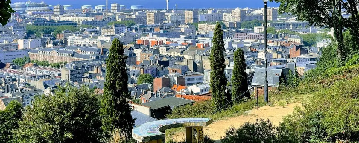 A panoramic view of Le Havre from a high vantage point, featuring the city's buildings and the port in the distance.
