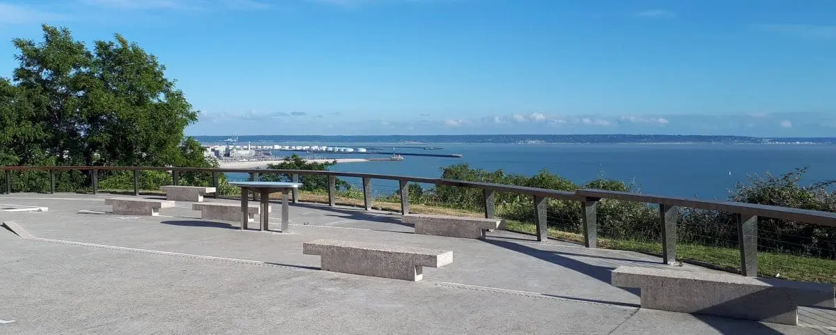 The viewpoint at Sainte Adresse in Le Havre, offering a clear view of the city and the harbor, with benches and a railing for visitors.